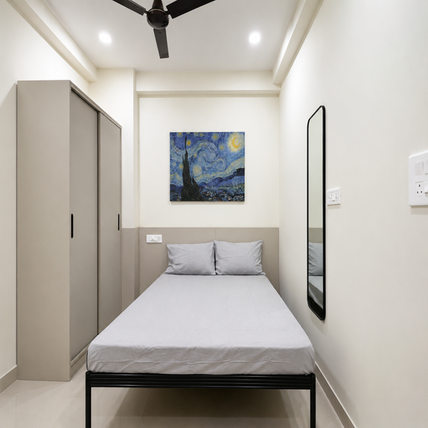 Bedroom, modern bedroom, minimalist bedroom, cozy bedroom, contemporary interior, interior design, home decor, sleeping area, double bed, white bed, white bedding, pillows, wardrobe, built-in wardrobe, storage cabinet, beige furniture, neutral colors, cream walls, accent wall, upholstered headboard, black bed frame, ceiling fan, recessed lighting, wall mirror, full-length mirror, electrical outlet, artwork, Starry Night, wall art, clean interior, compact bedroom, small bedroom, elegant interior, simple decor, modern furniture, bedroom furniture, residential interior, apartment bedroom, organized space, bright room, soft lighting, tiled floor, spacious feel, neutral palette, functional design, stylish bedroom, contemporary home, indoor photography, home interior, comfortable sleeping space.